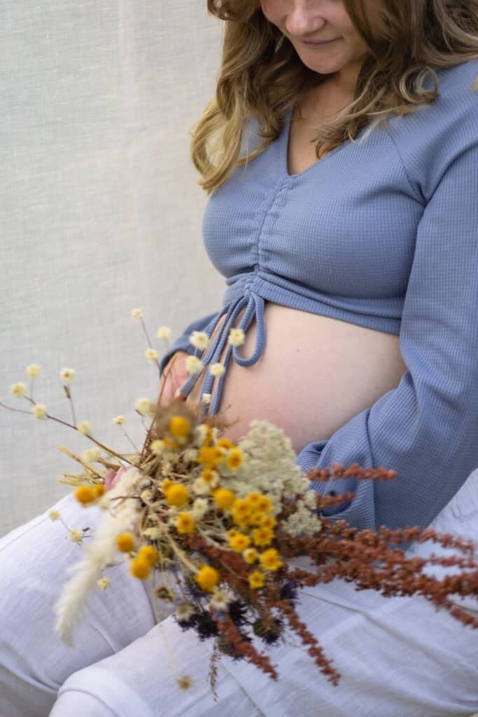 Bild einer schwangeren Frau mit einem Blumenstrauß