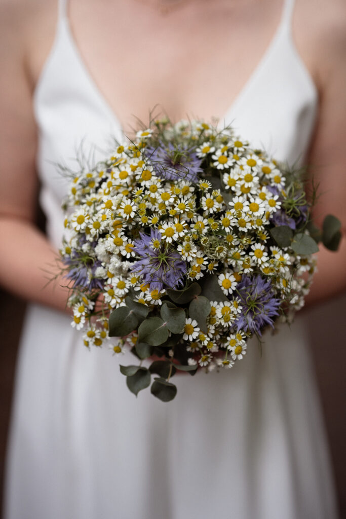 Nahaufnahme eines Brautstraußes in den Händen einer Braut